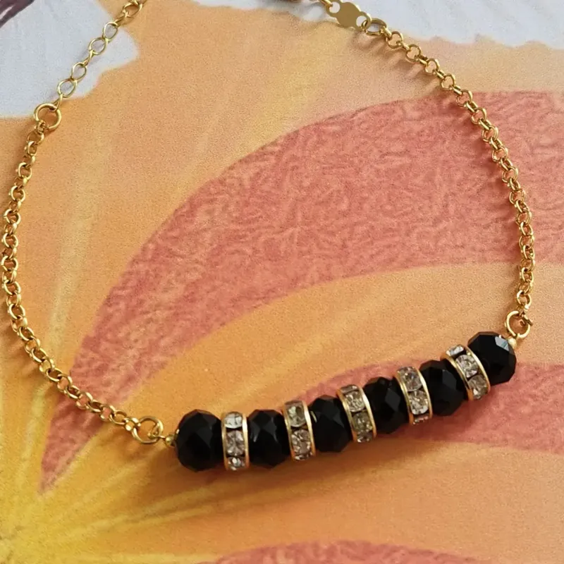 PULSEIRA DOURADA PEDRAS NEGRAS E CRISTAL