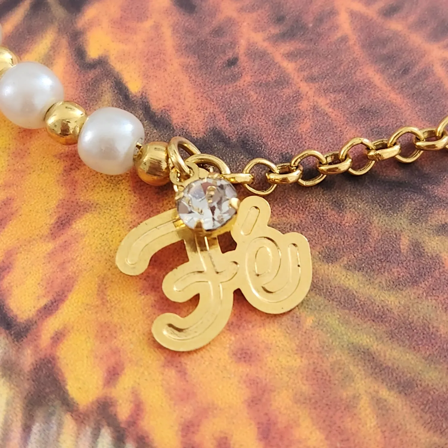 PULSEIRA DOURADA COM PÉROLAS PINGENTE FÉ