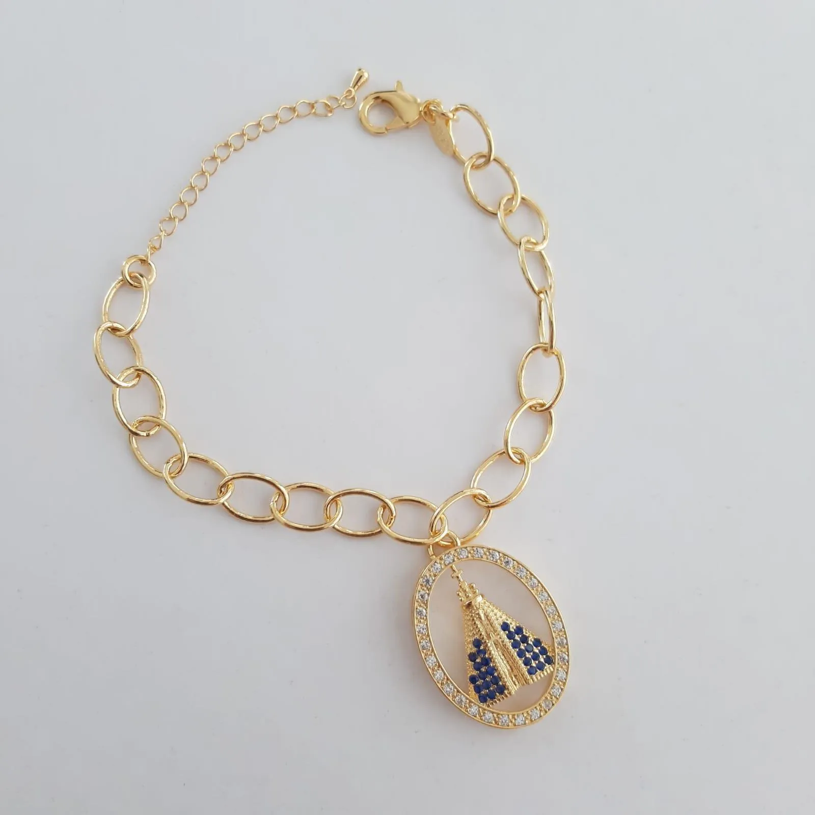 PULSEIRA DOURADA CORRENTE ELOS OVAIS PINGENTE NOSSA SENHORA APARECIDA CRAVEJADA EM MICROZIRCÔNIAS CRISTAL E SAFIRA