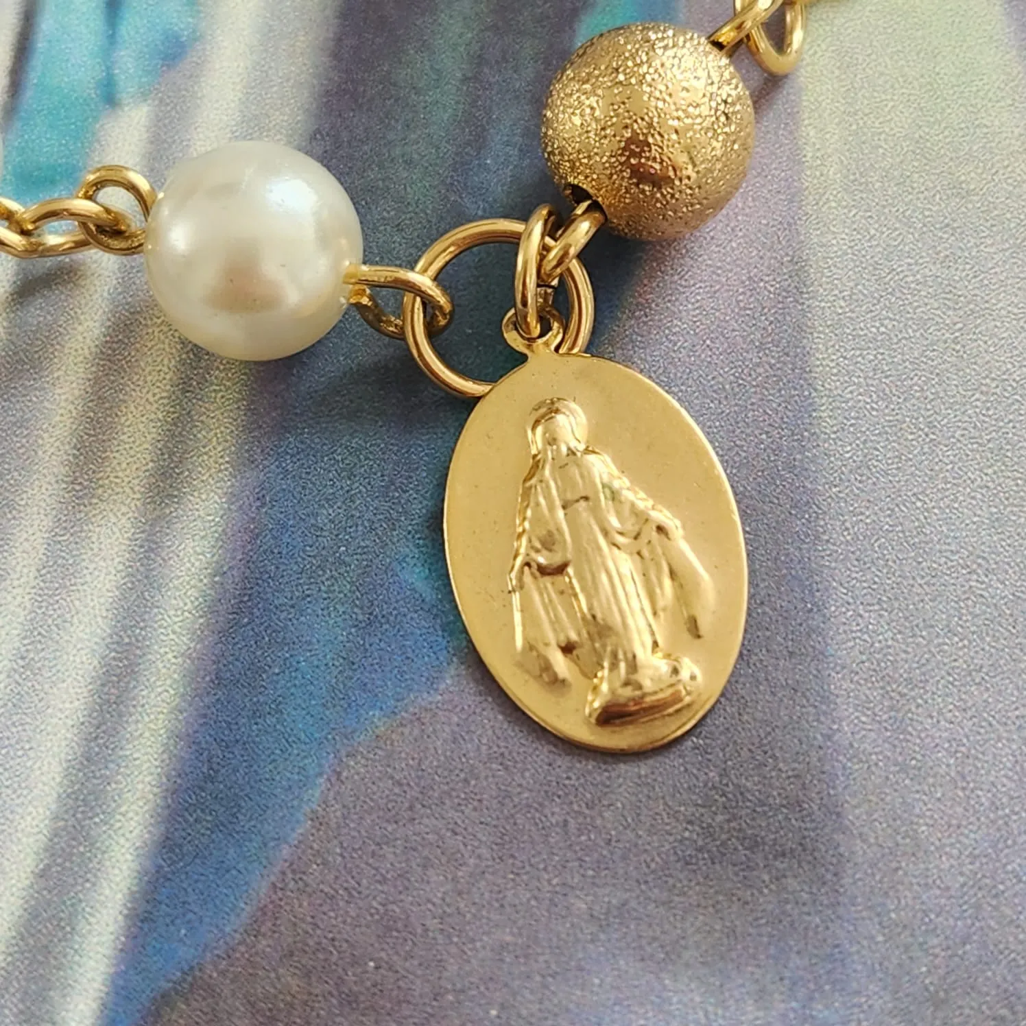 PULSEIRA DOURADA COM PÉROLAS E BOLA PINGENTE NOSSA SENHORA DAS GRAÇAS