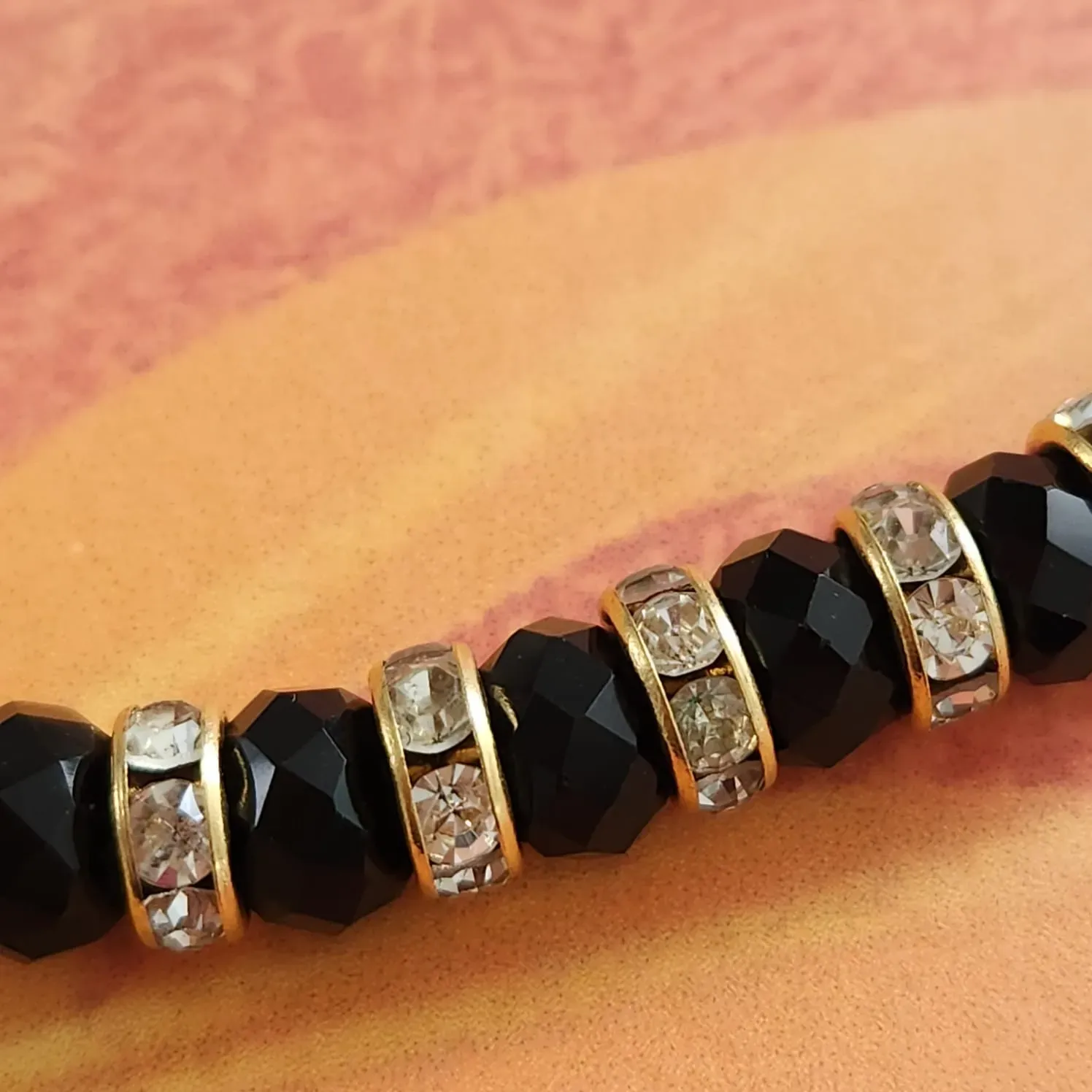 PULSEIRA DOURADA PEDRAS NEGRAS E CRISTAL