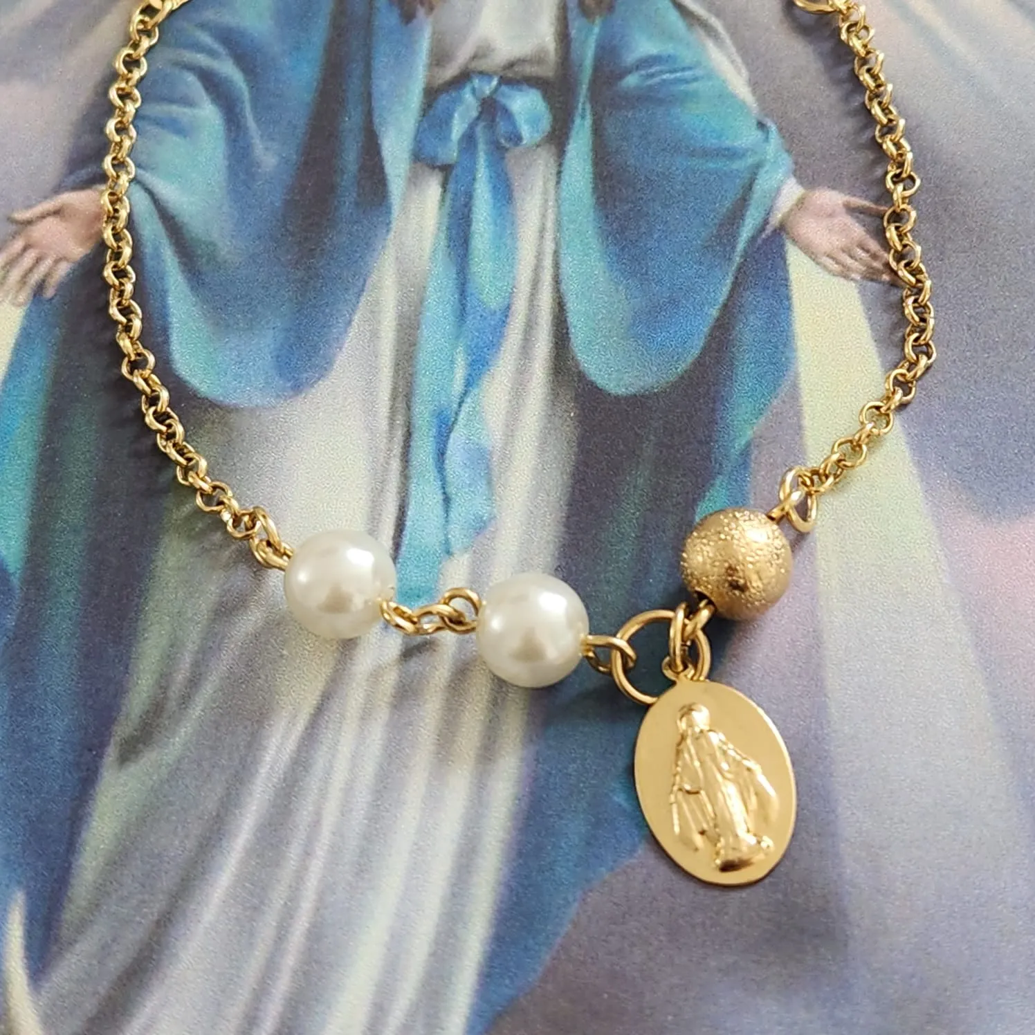 PULSEIRA DOURADA COM PÉROLAS E BOLA PINGENTE NOSSA SENHORA DAS GRAÇAS