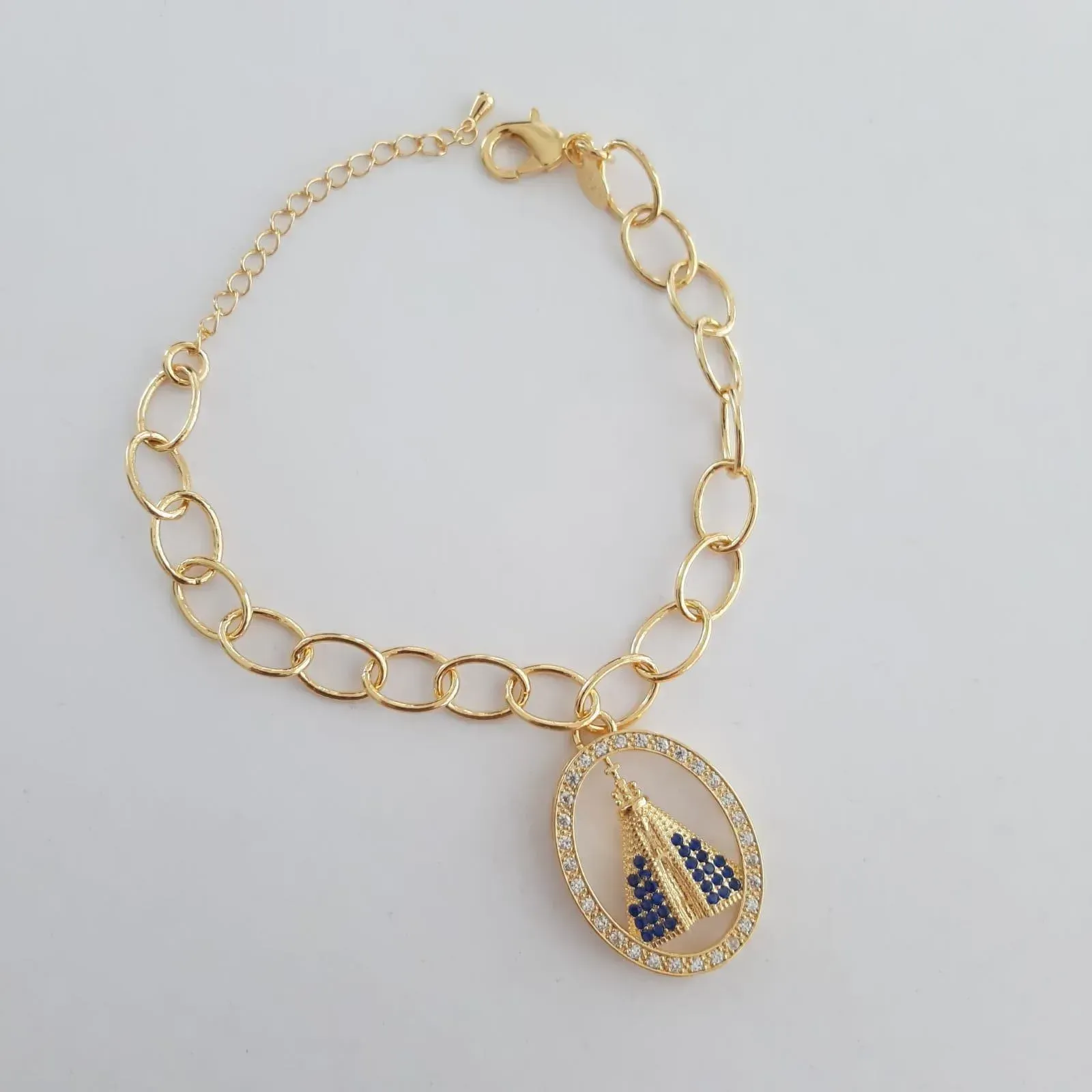 PULSEIRA DOURADA CORRENTE ELOS OVAIS PINGENTE NOSSA SENHORA APARECIDA CRAVEJADA EM MICROZIRCÔNIAS CRISTAL E SAFIRA