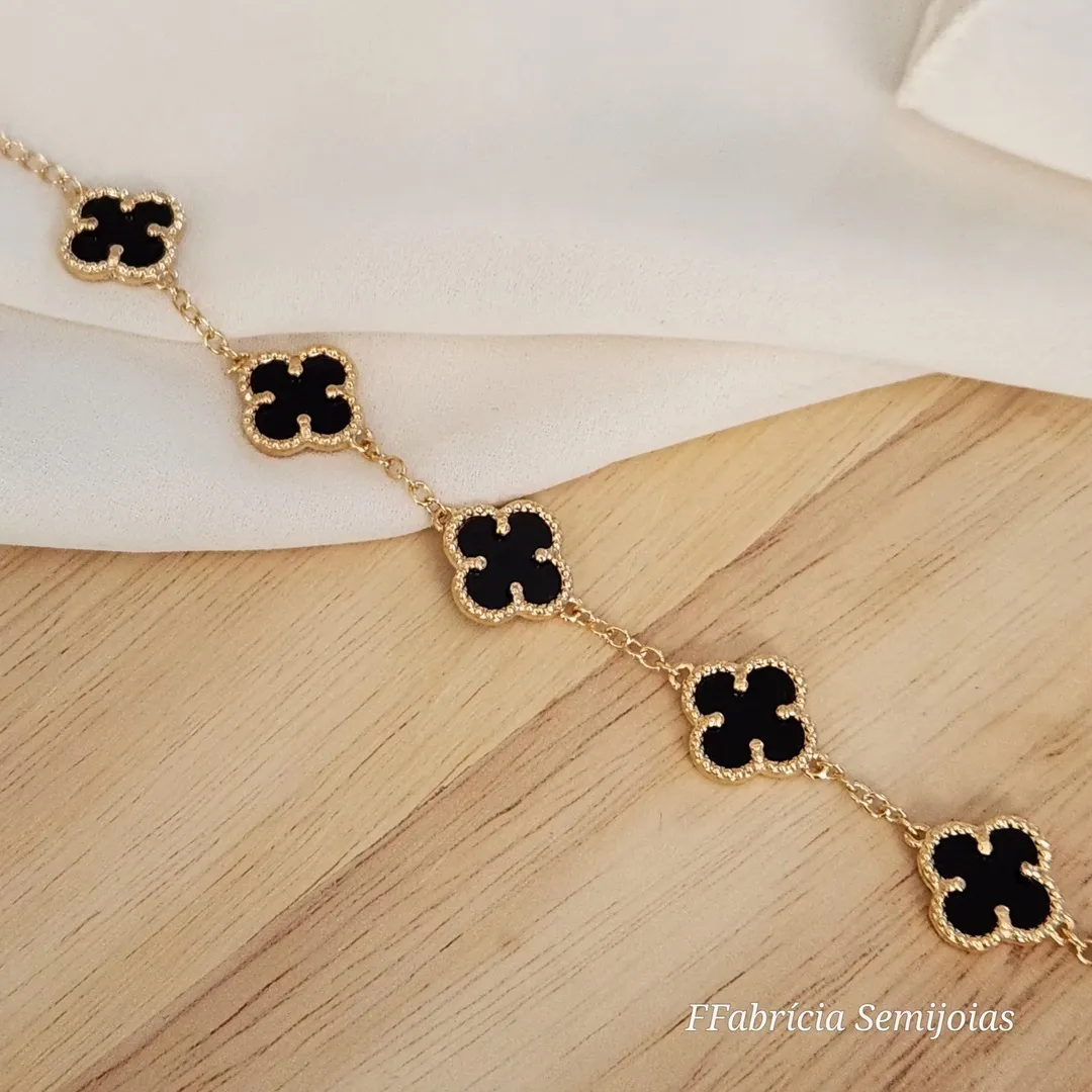 PULSEIRA COM 5 PINGENTES TREVO DE QUATRO FOLHAS PRETO BANHO OURO