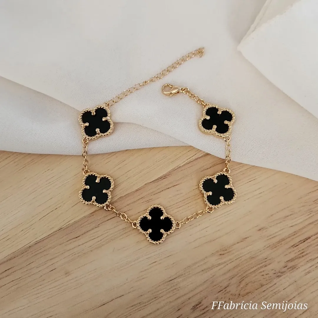 PULSEIRA COM 5 PINGENTES TREVO DE QUATRO FOLHAS PRETO BANHO OURO