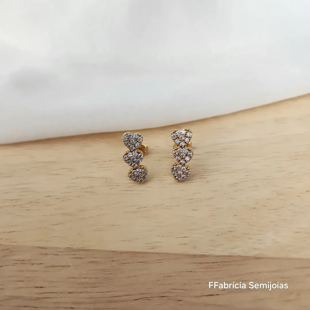 BRINCO DOURADO TRÊS CORAÇÕES CRAVEJADO EM MICROZIRCÔNIAS CRISTAL